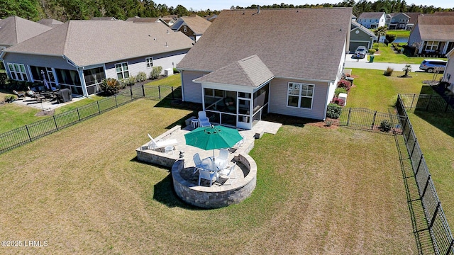 214 Lombards Mill Ln, Okatie, SC 29909 - rear view of property featuring a sunroom, a fenced backyard, a fire pit, a yard, and a patio area
