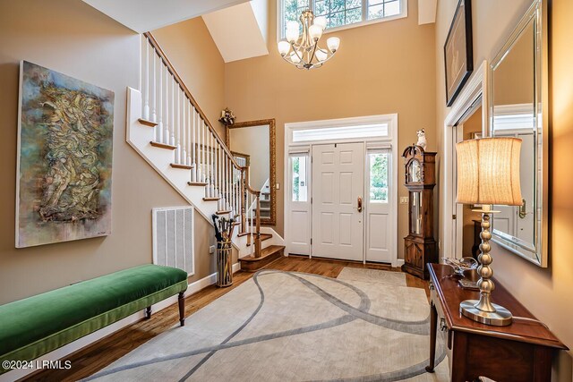 foyer with a high ceiling, an inviting chandelier, and light hardwood / wood-style floors