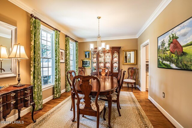 dining space featuring a notable chandelier, hardwood / wood-style flooring, and ornamental molding