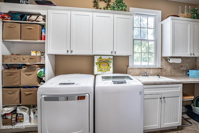 laundry room with cabinets, washing machine and dryer, and sink