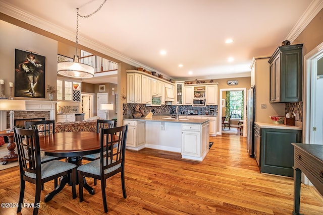 kitchen with hanging light fixtures, backsplash, a fireplace, and stainless steel appliances