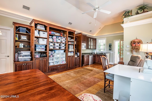 office space featuring dark hardwood / wood-style flooring, vaulted ceiling, ornamental molding, and ceiling fan