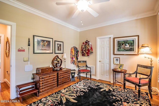 living area featuring hardwood / wood-style flooring, ceiling fan, and ornamental molding