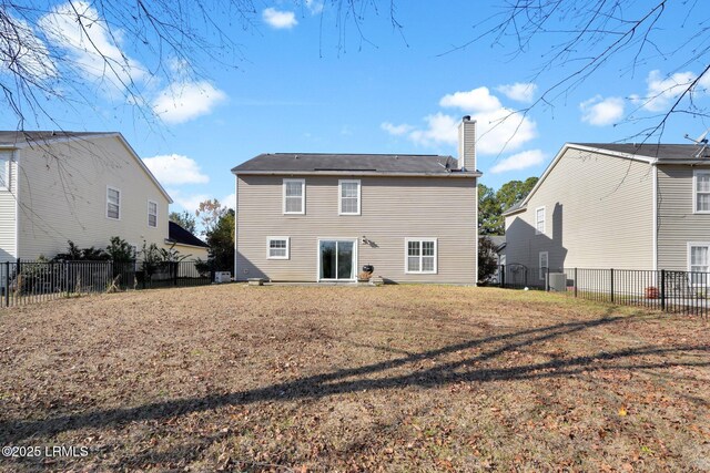 rear view of property featuring a lawn and central air condition unit