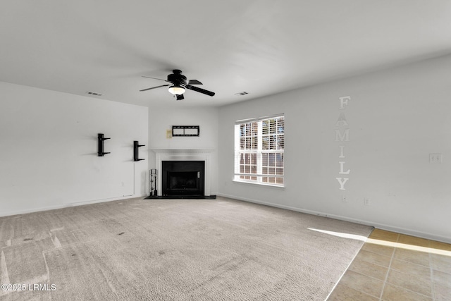 unfurnished living room featuring ceiling fan and light carpet