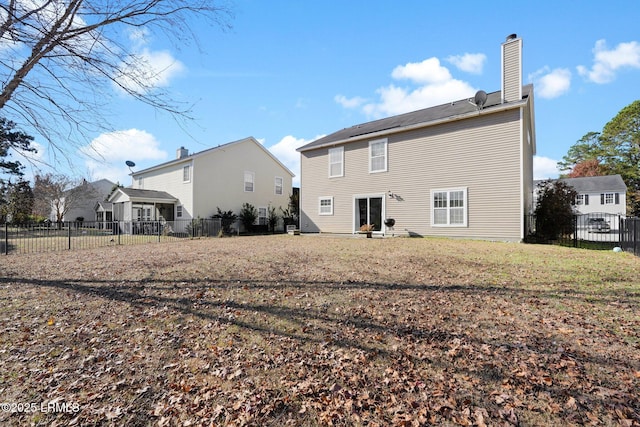 rear view of property featuring a lawn