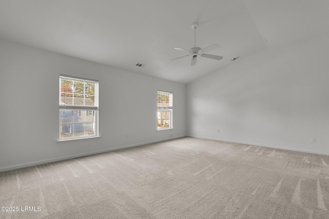 carpeted empty room featuring ceiling fan, a healthy amount of sunlight, and vaulted ceiling