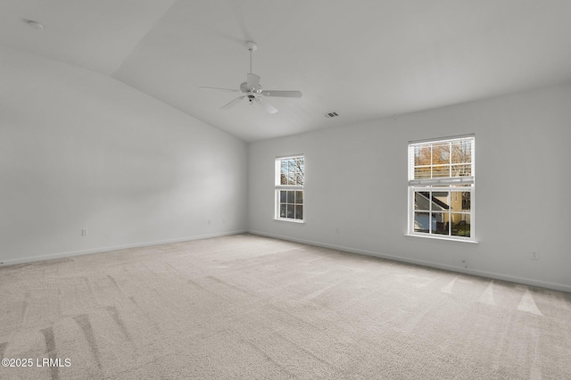 carpeted spare room with ceiling fan, vaulted ceiling, and a wealth of natural light