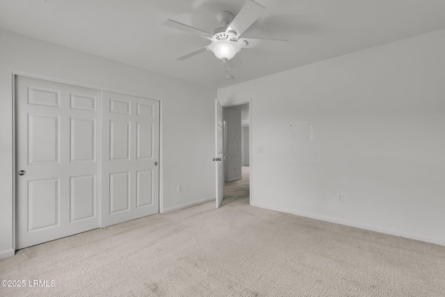 unfurnished bedroom featuring ceiling fan, light colored carpet, and a closet