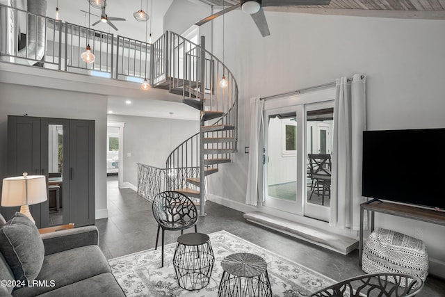 living room with a towering ceiling, a wealth of natural light, and ceiling fan