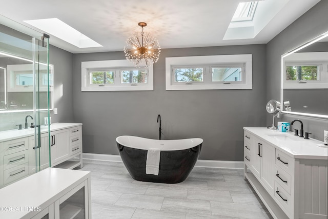 bathroom with a washtub, vanity, and a skylight