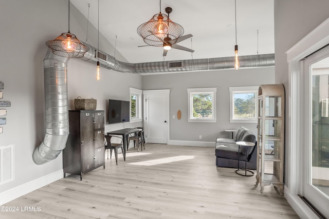 living area featuring ceiling fan, light wood-type flooring, and high vaulted ceiling