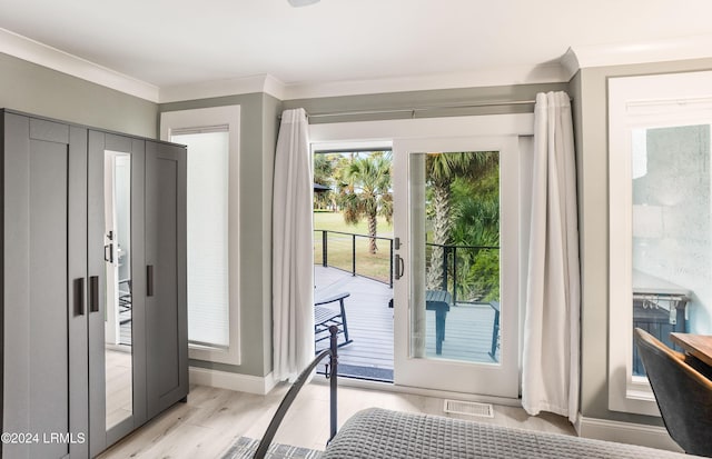 doorway featuring ornamental molding and light hardwood / wood-style floors