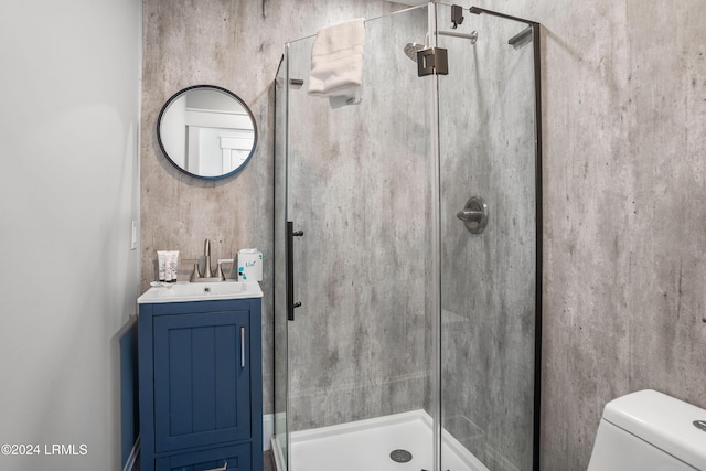 bathroom featuring an enclosed shower, vanity, and toilet