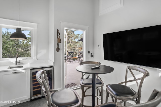 dining space with wine cooler, plenty of natural light, and indoor wet bar