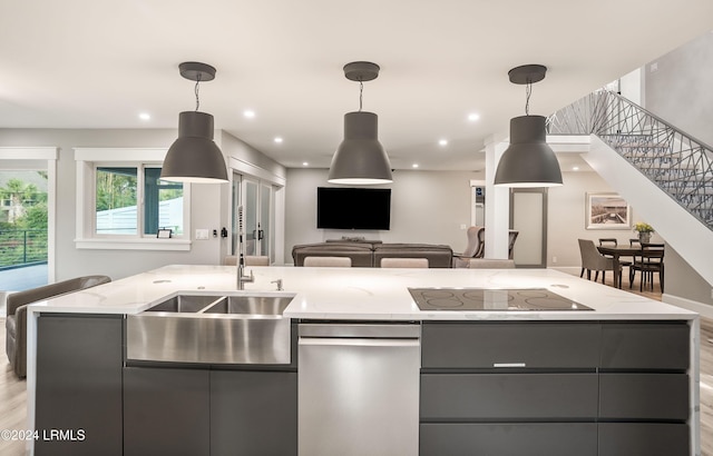 kitchen with hanging light fixtures, an island with sink, and black electric stovetop