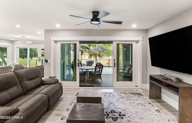 living room with light hardwood / wood-style floors, french doors, and a healthy amount of sunlight