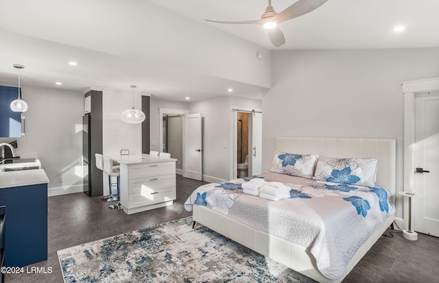 bedroom featuring vaulted ceiling, ceiling fan, a barn door, and sink