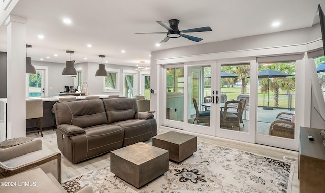 living room featuring ceiling fan, light hardwood / wood-style floors, and french doors