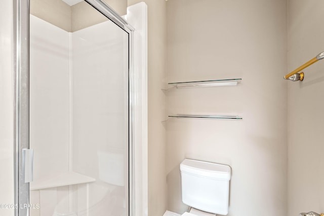 bathroom featuring toilet and a shower stall