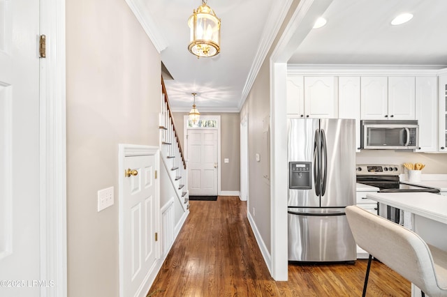 kitchen featuring white cabinets, ornamental molding, stainless steel appliances, and light countertops