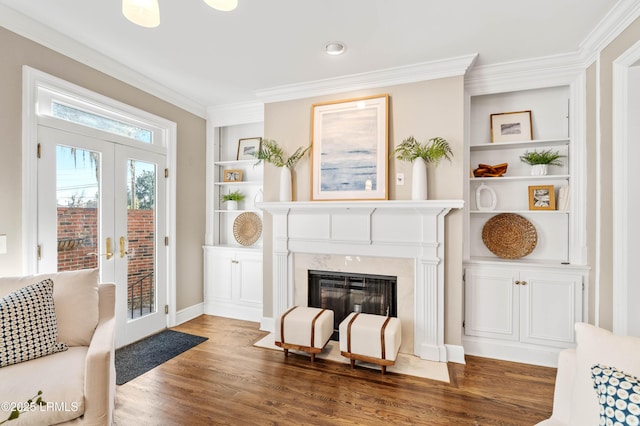 interior space featuring built in shelves, ornamental molding, wood finished floors, and french doors