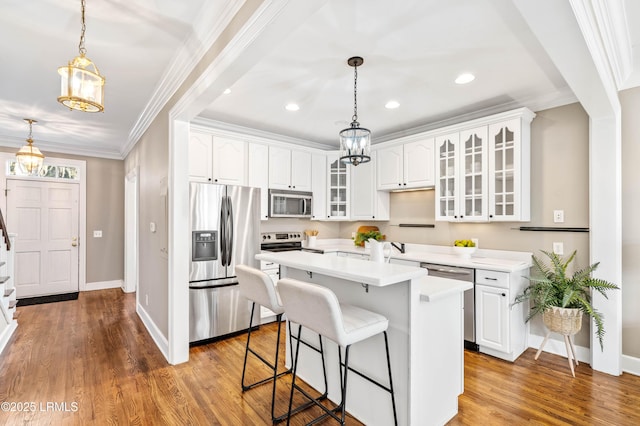 kitchen featuring white cabinets, glass insert cabinets, a center island, stainless steel appliances, and light countertops