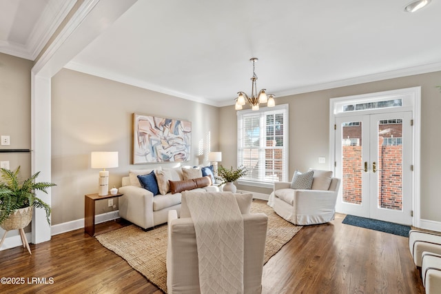 living room featuring french doors, a notable chandelier, crown molding, and wood finished floors