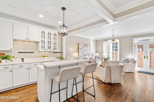 kitchen featuring white cabinets, glass insert cabinets, light countertops, and french doors