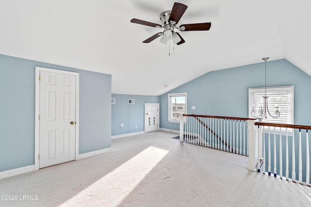 bonus room with lofted ceiling, light carpet, baseboards, and ceiling fan with notable chandelier