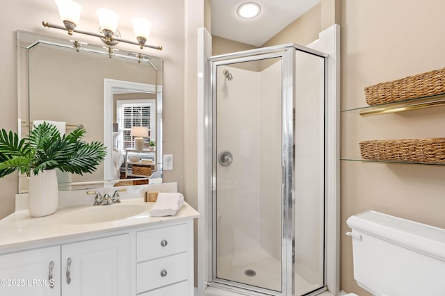 bathroom with toilet, a stall shower, and vanity