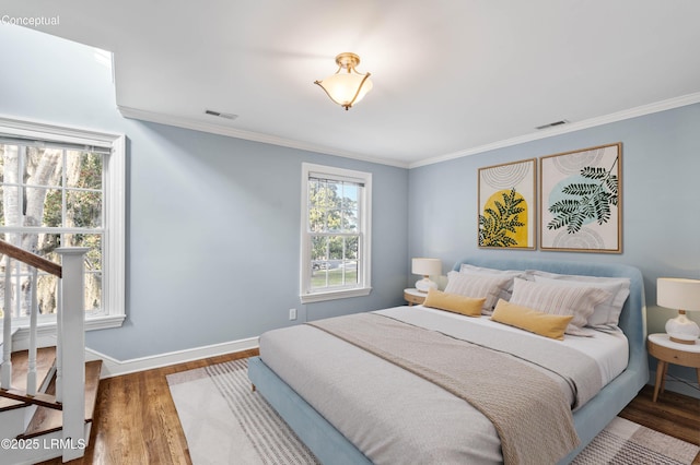 bedroom featuring crown molding, visible vents, baseboards, and dark wood-style flooring