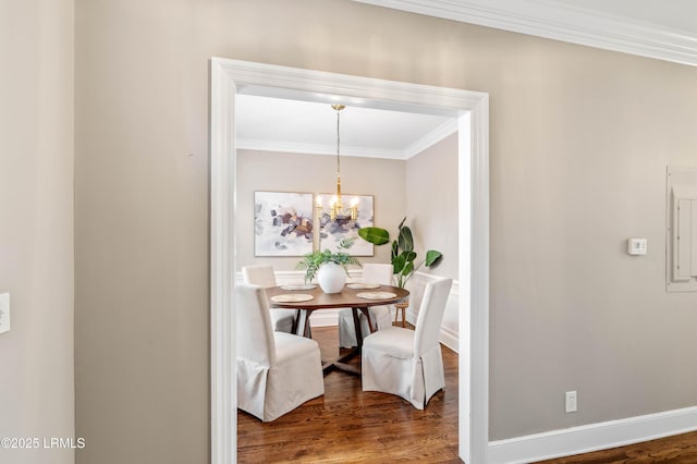 dining area with a notable chandelier, crown molding, baseboards, and wood finished floors