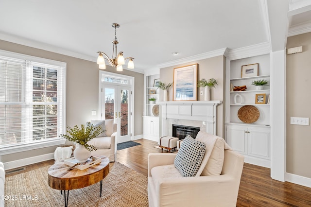 living area featuring ornamental molding, built in shelves, dark wood-type flooring, and visible vents