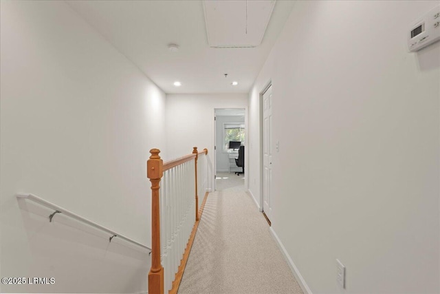 corridor with attic access, light carpet, baseboards, recessed lighting, and an upstairs landing