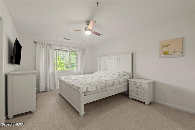 bedroom with baseboards, a ceiling fan, visible vents, and light colored carpet