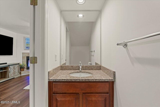bathroom featuring wood finished floors, vanity, and recessed lighting