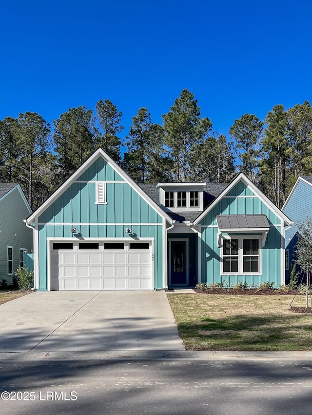 view of front of house featuring driveway, a garage, roof with shingles, a front lawn, and board and batten siding