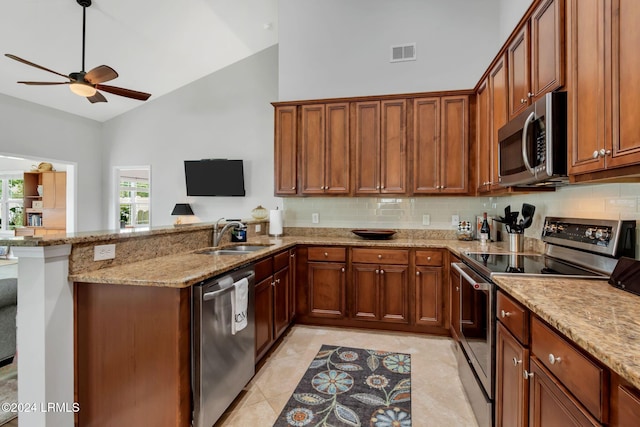 kitchen featuring high vaulted ceiling, sink, stainless steel appliances, and kitchen peninsula