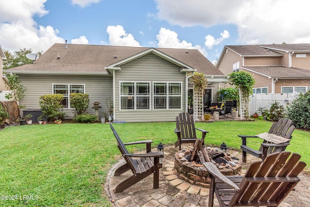 rear view of house featuring a yard, a patio area, and a fire pit