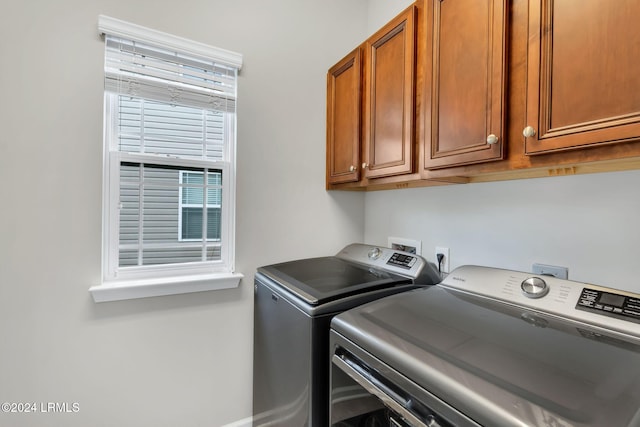 washroom with cabinets and washing machine and clothes dryer