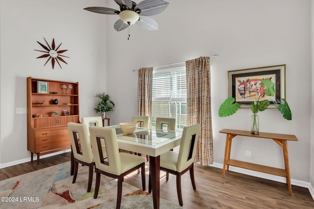 dining area with dark wood-type flooring and ceiling fan