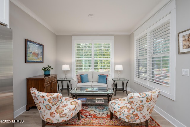 sitting room with baseboards, a wealth of natural light, and light wood finished floors