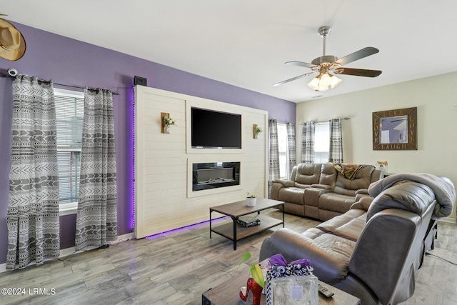 living room featuring ceiling fan, plenty of natural light, and light hardwood / wood-style floors