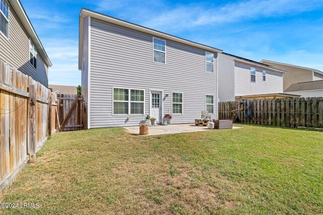 rear view of property featuring a yard and a patio area