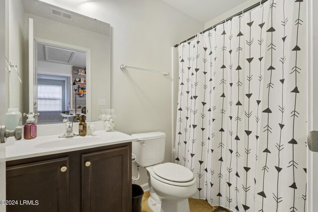 bathroom featuring vanity, toilet, and curtained shower