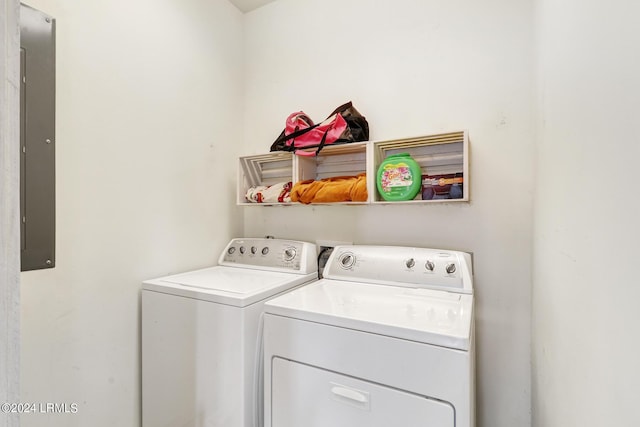 laundry room with electric panel and washer and clothes dryer