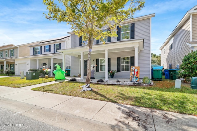 townhome / multi-family property featuring covered porch and a front lawn