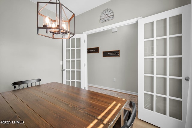 unfurnished dining area with french doors and an inviting chandelier