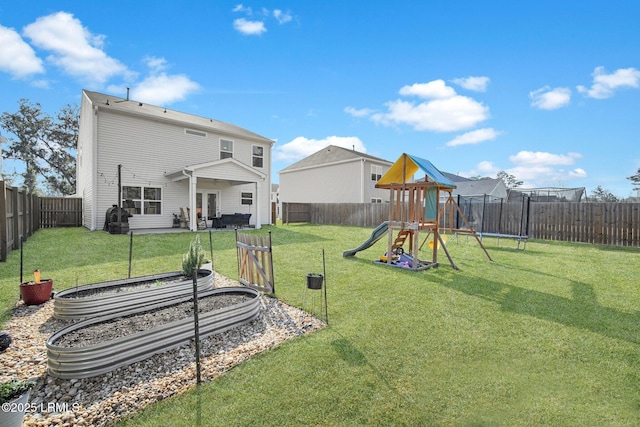 exterior space featuring a playground, a trampoline, a vegetable garden, and a lawn